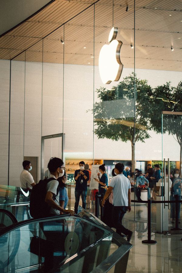 Shoppers passing a retail advertising screen